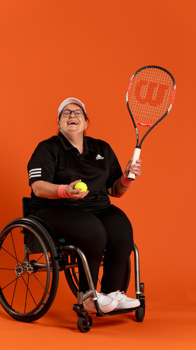 Emily laughing while playing wheelchair tennis