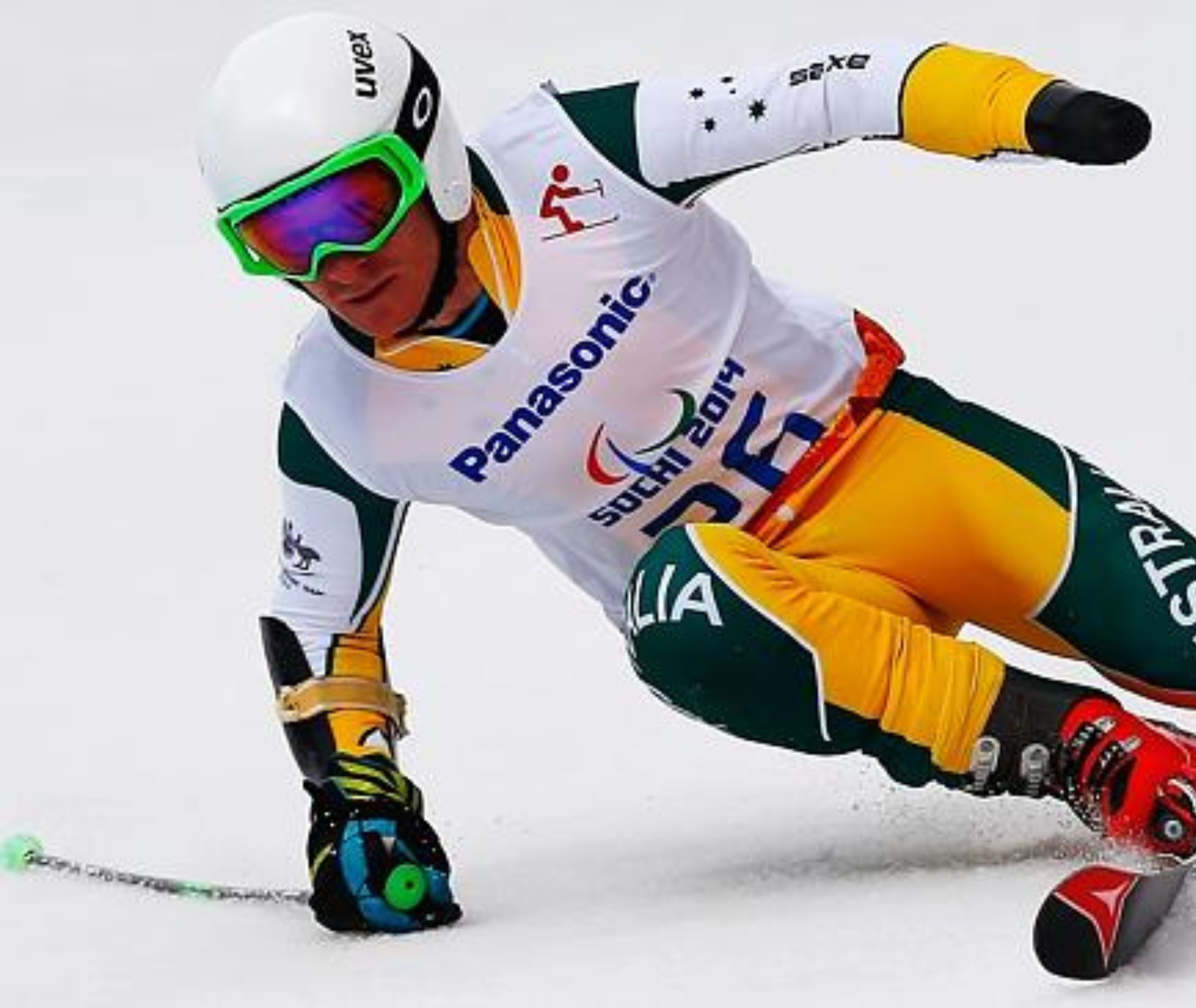 Mitch Gourley. National Manager; an alpine skier in action, wearing Australian national team gear, is captured as he is about to make a turn in the snow.