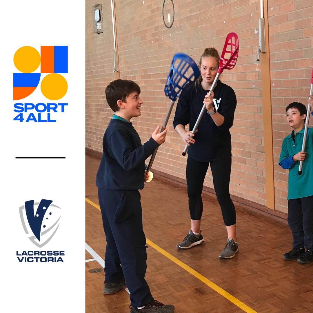 In the image, three people are shown at a lacrosse training session. In the center, the coach stands, demonstrating technique to one of the students who is holding a lacrosse bat. The coach is actively instructing the student while showing them proper form. On either side of the coach, two students are mimicking the coach's actions, also holding lacrosse bats as they practice the demonstrated technique. Below the image the Sport4All and Lacrosse Vic logos are shown.