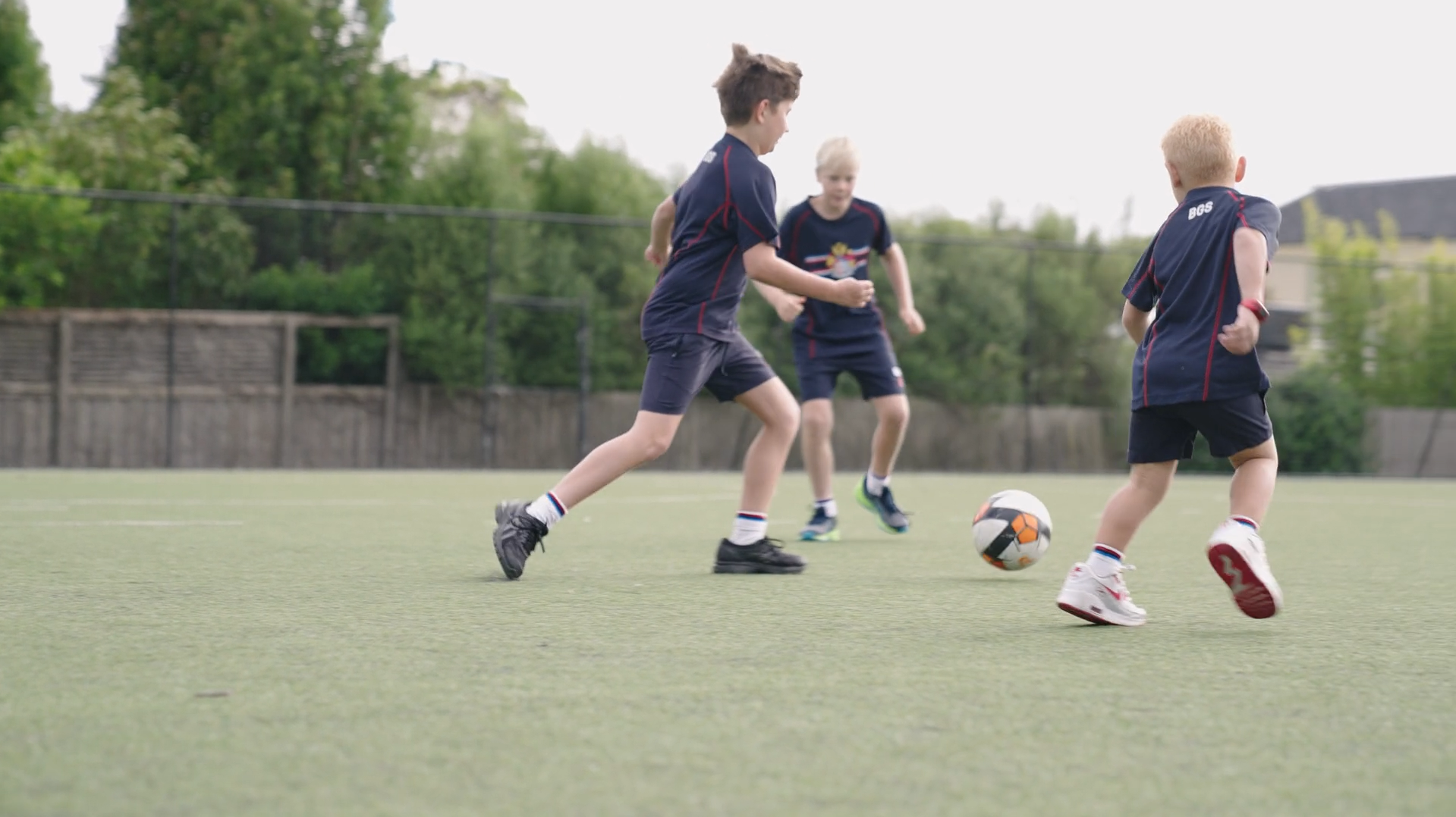 Kids playing soccer on a field.