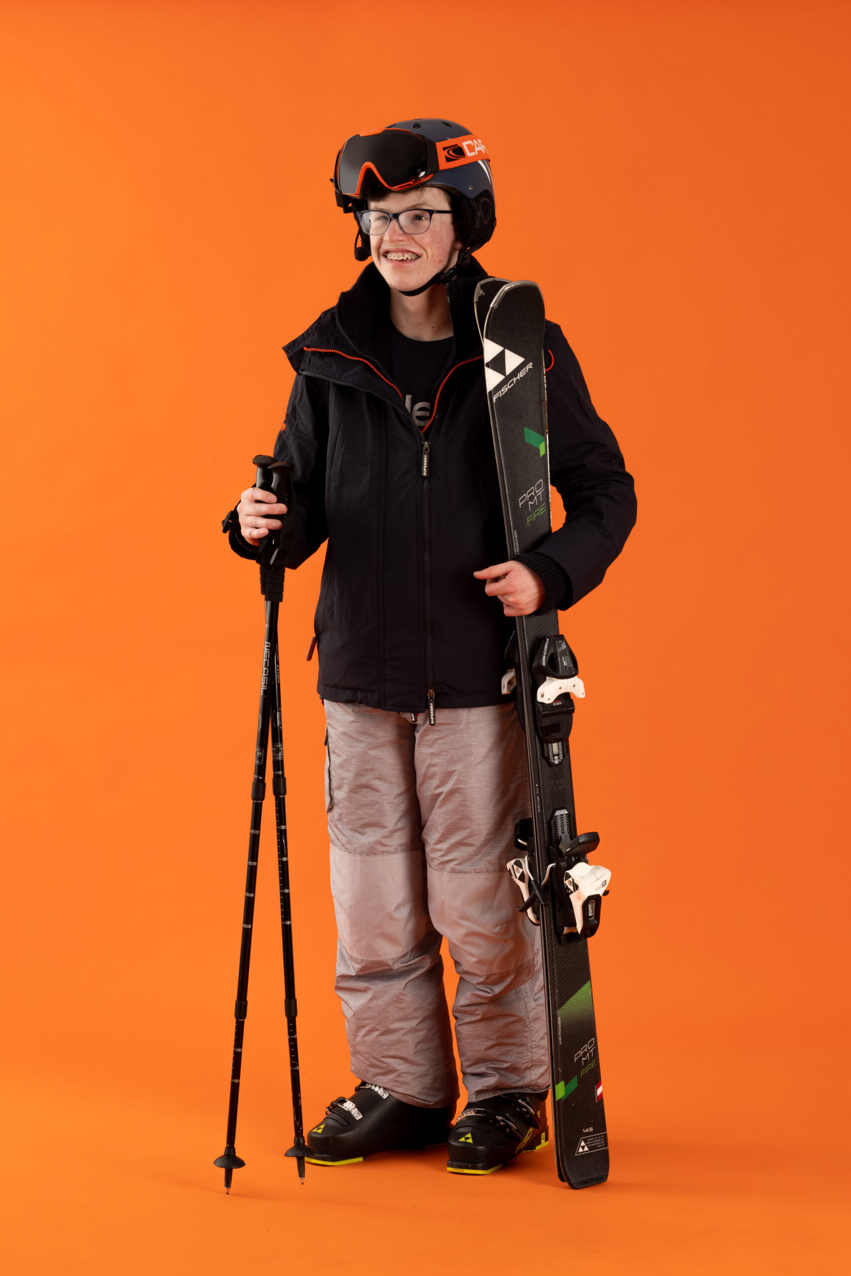 Kid with a disability holding snowboarding gear.