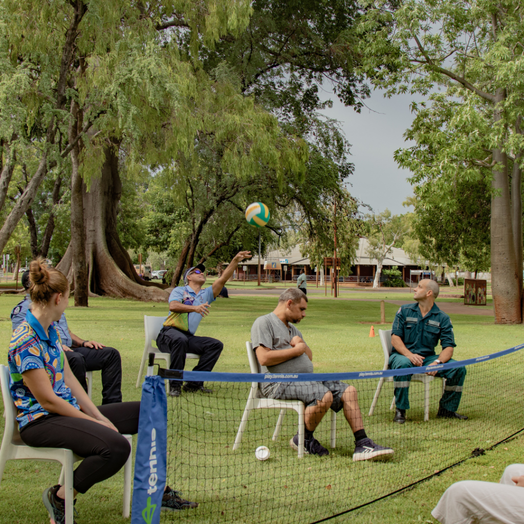 Participants playing seated volleyball.