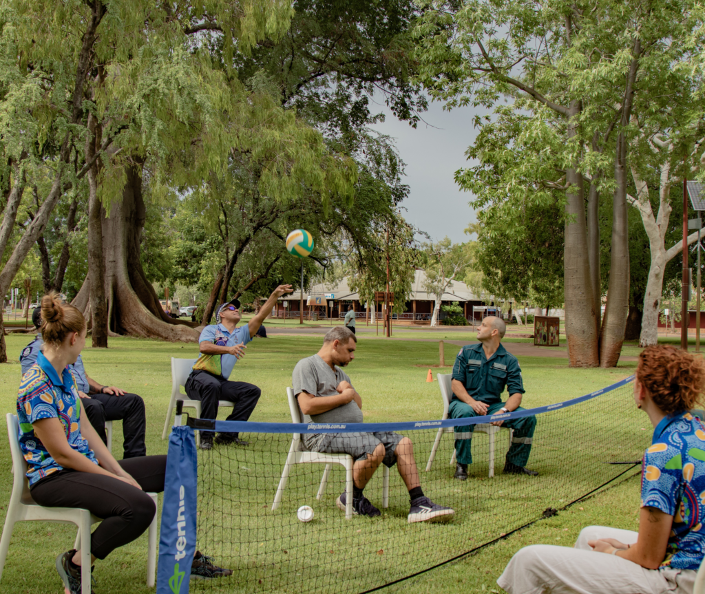 Participants playing seated volleyball.