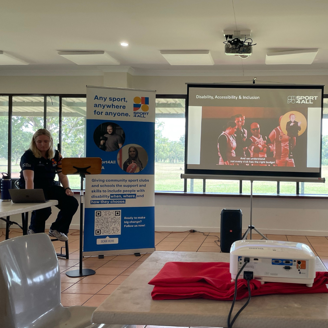 Sport4All Inclusion Coach in front of the room speaking to poeple seated. She has Sport4All presentation on the big screen