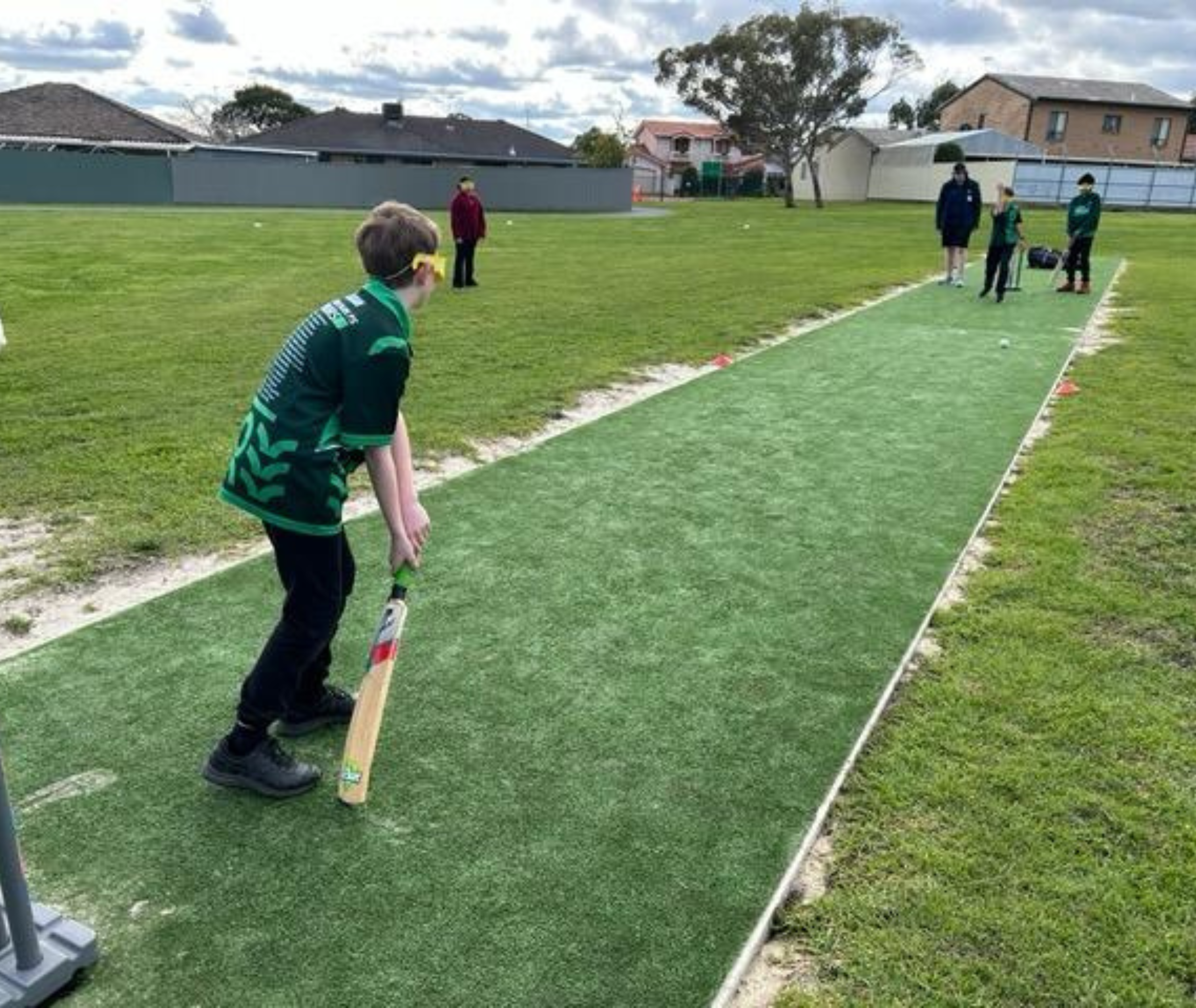 Student batting on a cricket pitch