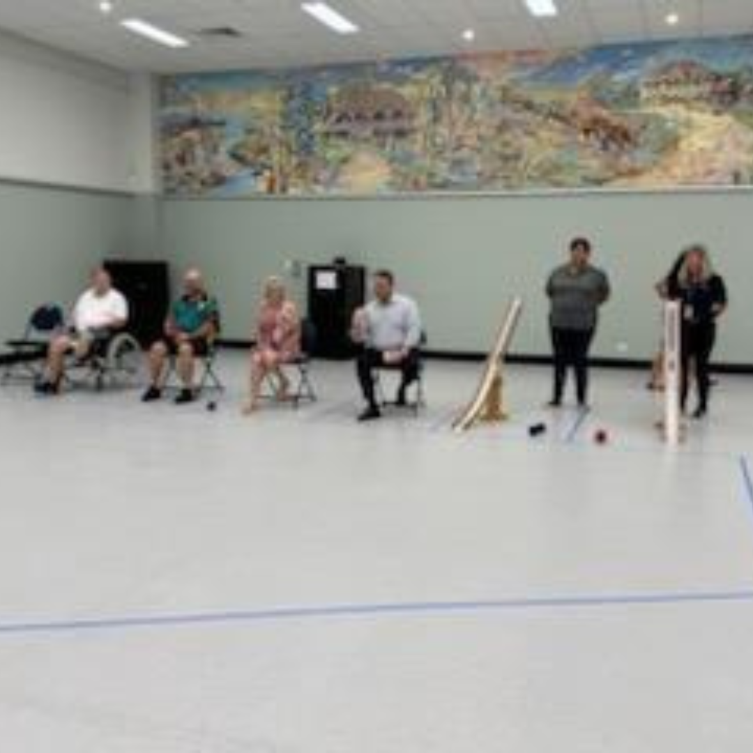 A panel of adults sit at the front of a hall during a Sport4All session.