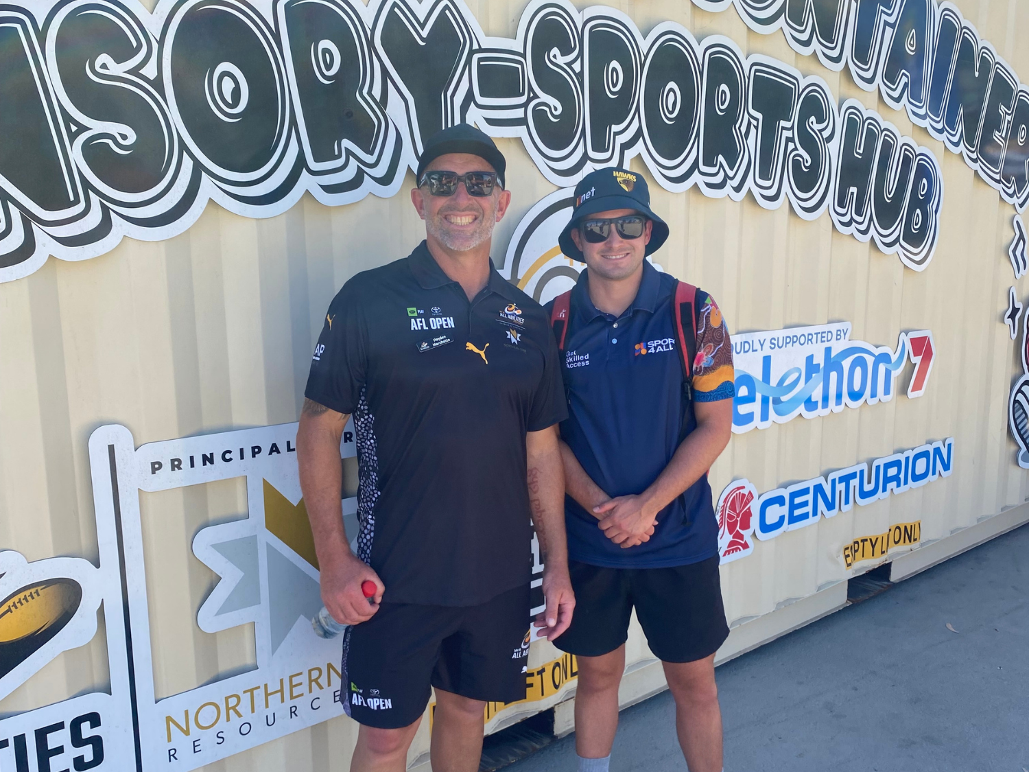 Michael Bourgault du Coudray, Sport4All Inclusion Coach, stands beside the Sensory-Sports Hub container at an event.