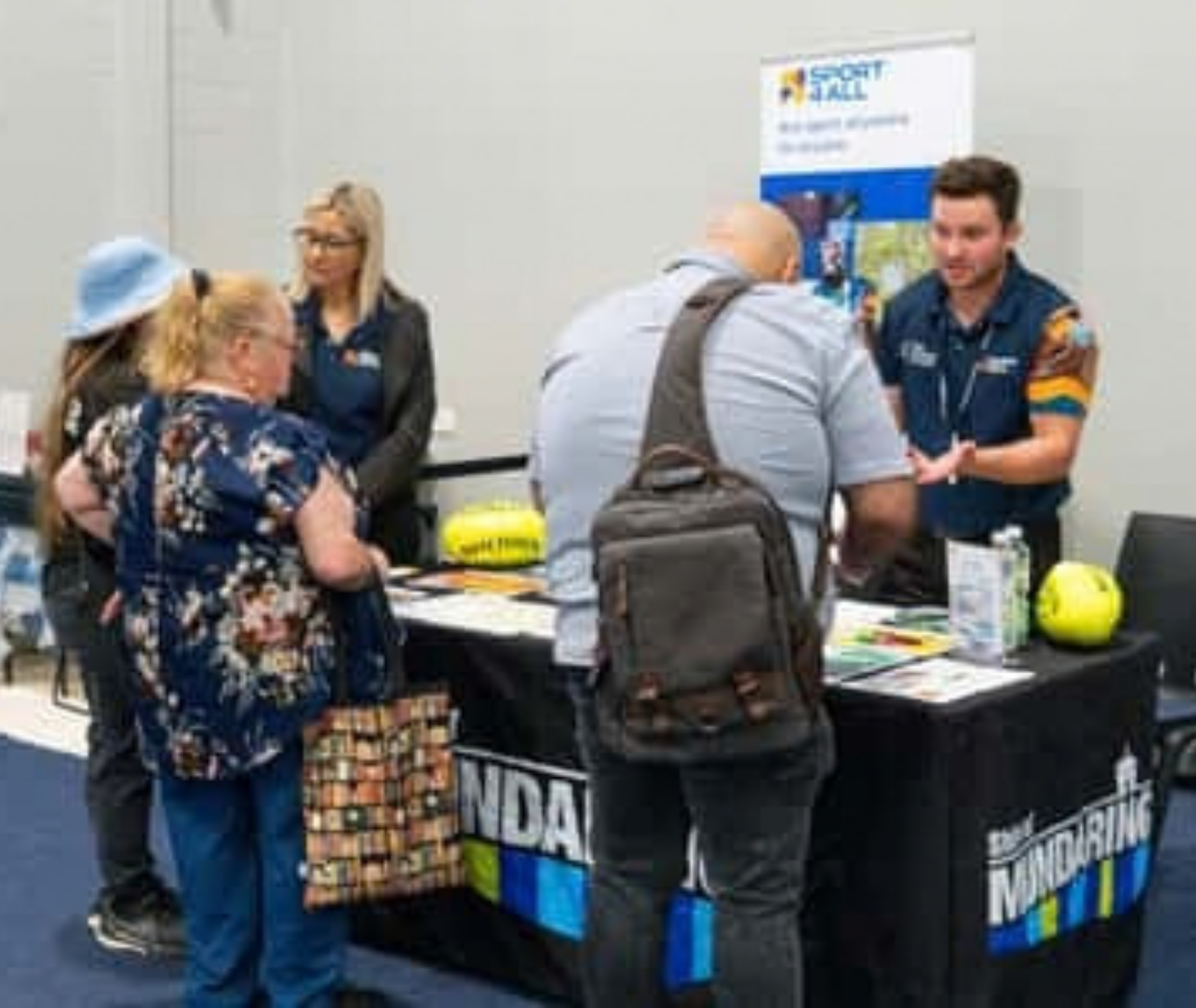 Community members visit a Sport4All information stall at an event.