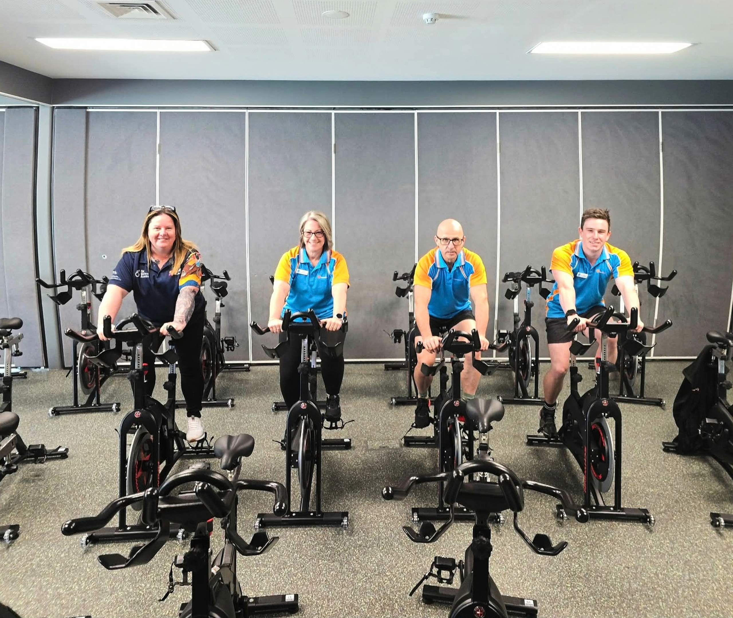 Sport4All Inclusion Coach, Jo with Splash team members on an exercise bike.